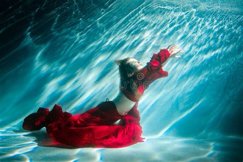 Attractive Red-haired Young Woman Swims Beautifully Underwater in a Red Dress. Stock Photo ...
