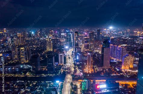 Aerial night cityscape of skyscrapers and multi lane highway traffic in ...