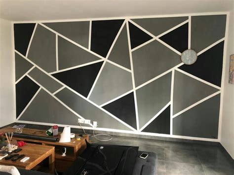 a living room with black and white geometric wallpaper