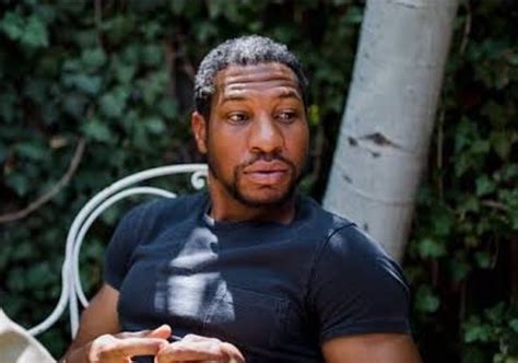 a man sitting on a white chair holding something in his hand