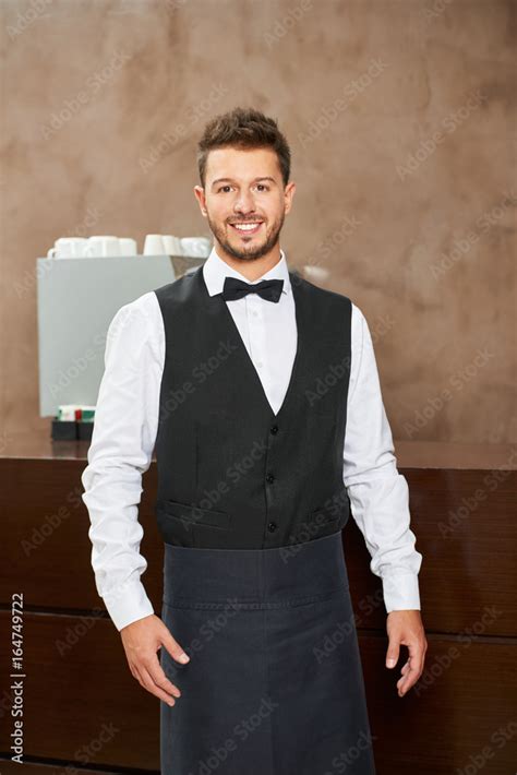 Friendly waiter in uniform in a restaurant Stock Photo | Adobe Stock