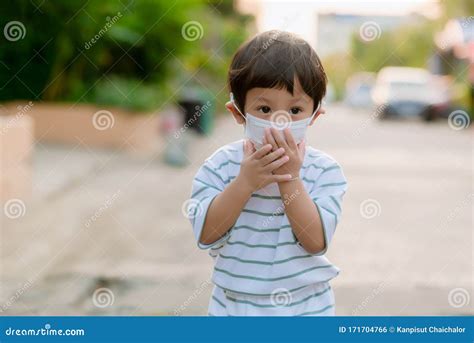 Child Wearing a Protective Face Mask on a City Street with Air ...