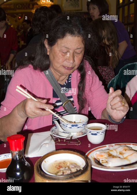 Woman eating dim sum in a Chinese restaurant, Chinatown, London ...