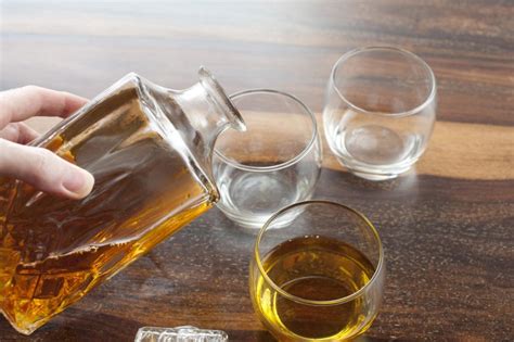 Man pouring tumblers of whiskey - Free Stock Image