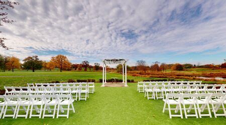 an outdoor ceremony set up with white chairs