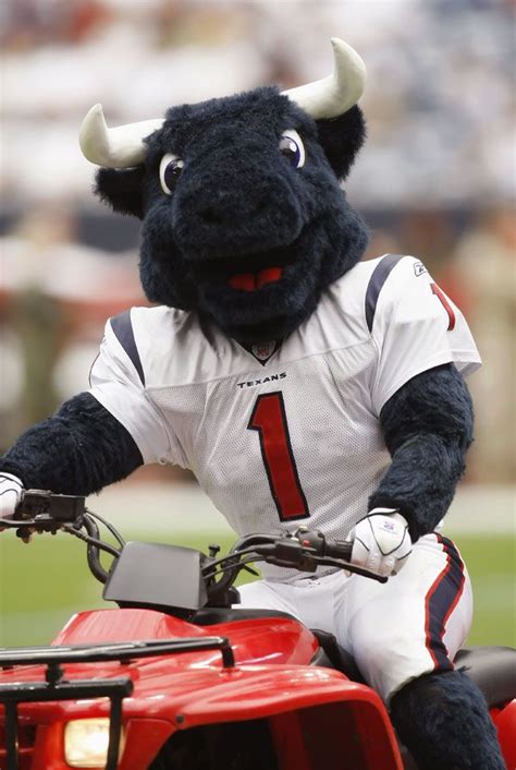 a mascot riding on the back of a red four - wheeler at a football game
