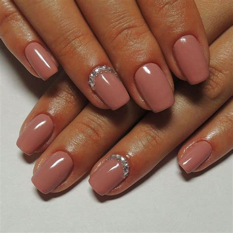 a woman's hand with pink manies and diamond accented nail polish on it