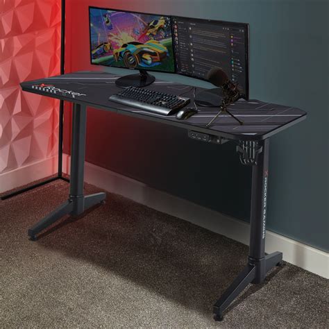 a computer desk with a keyboard and mouse on it in front of a red wall