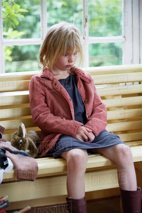 Sad girl sitting on bench - Stock Photo - Dissolve