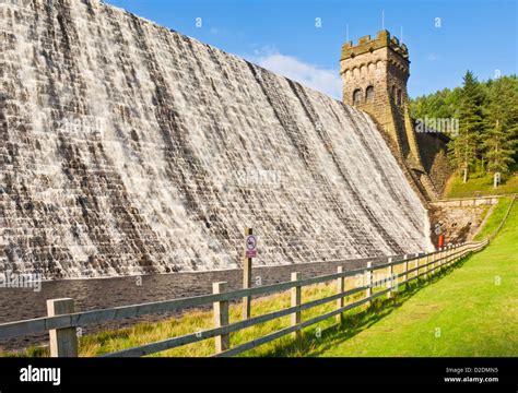 Dam wall with water overflowing Derwent reservoir Derbyshire Peak district national park ...