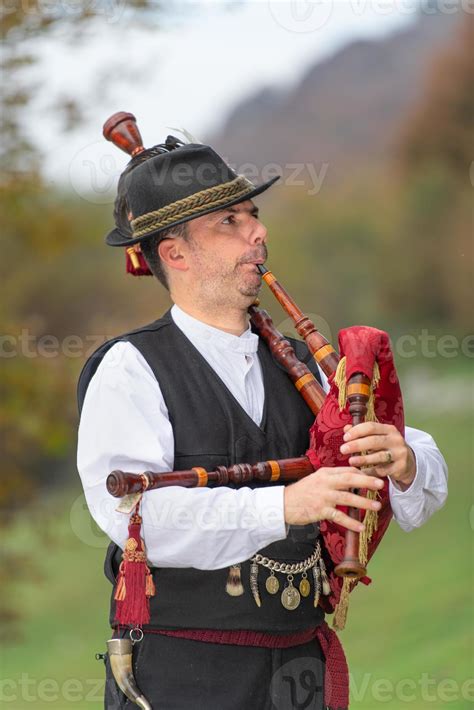 Typical player in traditional northern Italy bagpipe costume, an alpine valley of Bergamo ...