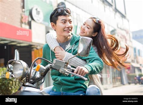 Young couple riding motorcycle together Stock Photo - Alamy