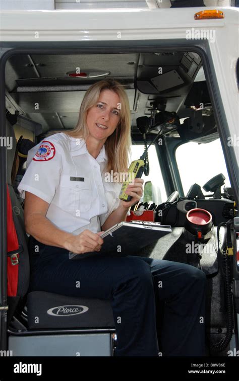 Female firefighter paramedic EMT in dress uniform looking at camera ...