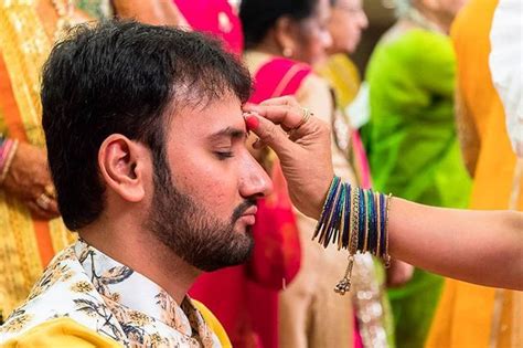 The groom is welcomed at his Hindu wedding with a Tilaka ceremony. Rice is a symbol of ...