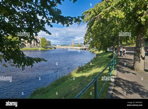 Looking north up tree lined footpath beside River ness (towards city centre) and Ness Bridge ...