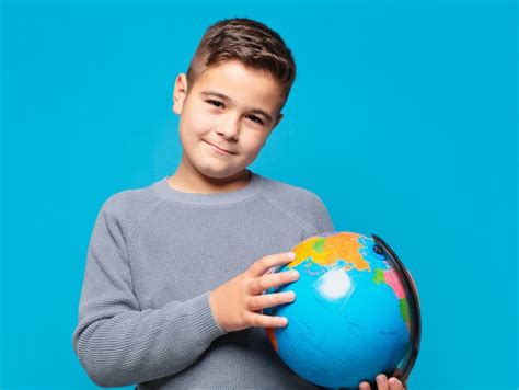 Premium Photo | Little boy happy expression and holding a world map model