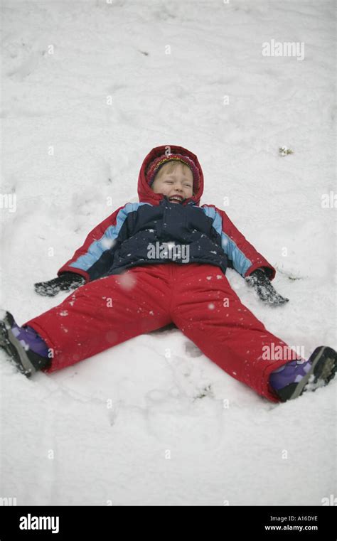 4 year old girl making snow angels Stock Photo - Alamy