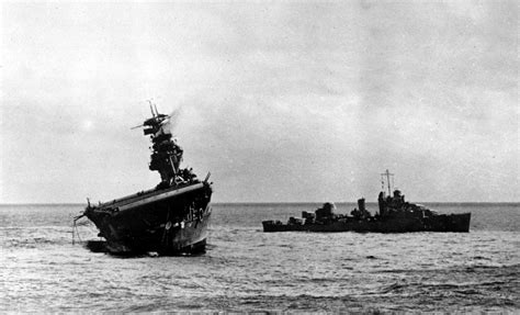 USS Yorktown (CV-5) lists heavily to port after being struck by Japanese bombers and torpedoes ...