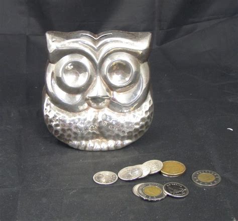 an owl statue sitting next to some coins