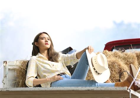 Premium Photo | A woman in a cowgirl style sits in a horse ranch with a western farm environment.