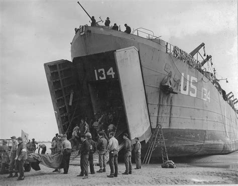 US Navy LST-134 and LST-325 beached at Normandy, as jeeps driving along ...