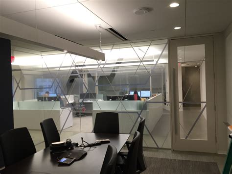 A glass conference room with freshly installed printed polyester film with line graphics. This ...