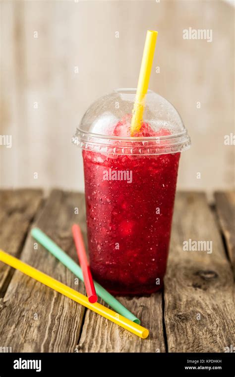 frozen red slushie in plastic cup with straw Stock Photo - Alamy