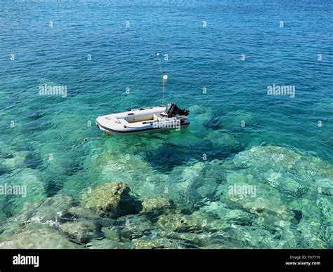 Inflatable motor boat anchored in crystal clear water at Agia Pelagia ...