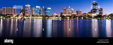 Glowing nighttime downtown skyline of Orlando Florida reflects in Lake ...