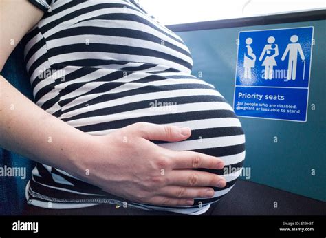 Pregnant woman sitting in a priority seat on a London bus, England Stock Photo: 69667272 - Alamy