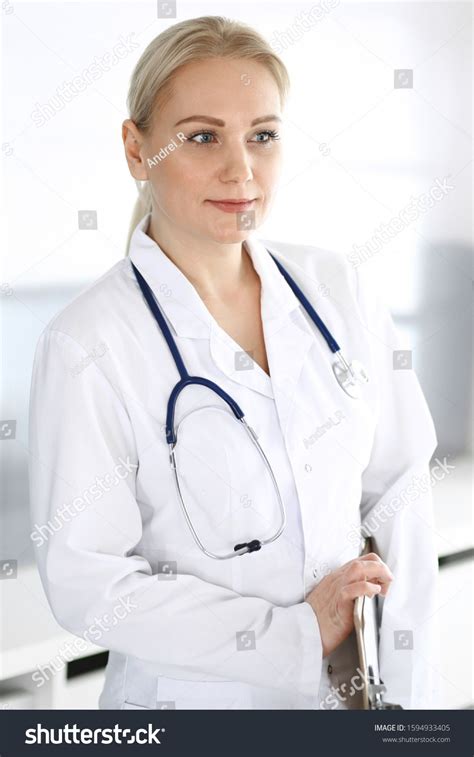 Doctor woman adult standing straight in hospital office, portrait. Perfect medical service in ...