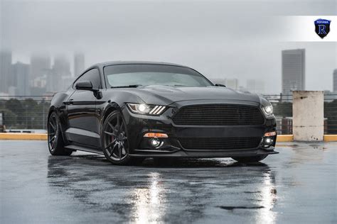 a black car parked on top of a wet parking lot