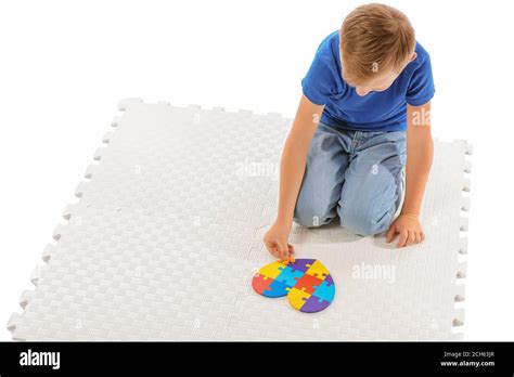 Little boy with autistic disorder doing puzzle on white background Stock Photo - Alamy