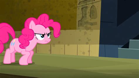 the pinkie pony is standing in front of a brick wall and looking at ...