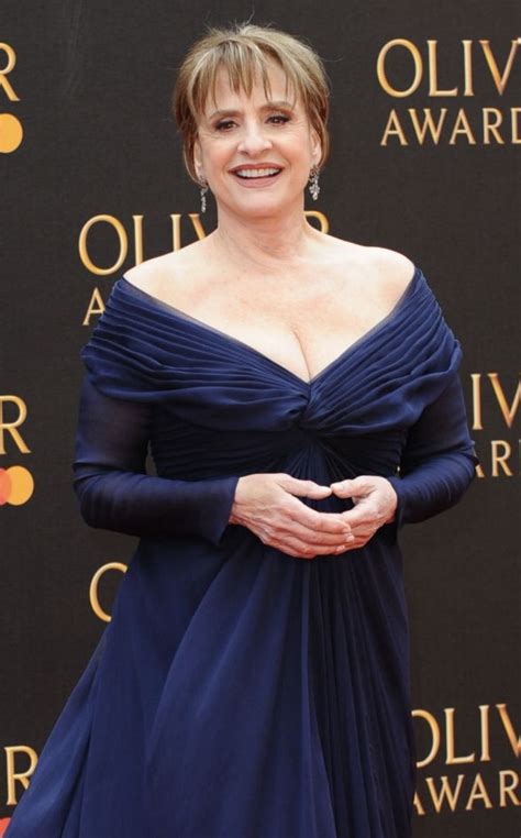 a woman in a blue dress standing on the red carpet at an awards ceremony with her hands folded out