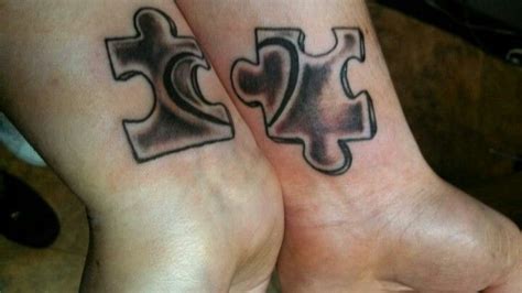 two people with matching tattoos on their feet are holding hands and one has a puzzle piece in ...