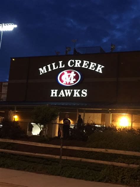 the entrance to mill creek hawks stadium lit up at night with people ...