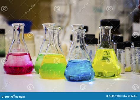 Different Colorful Solution in Conical Flask on a Bench in a Chemistry Lab with Blur Background ...