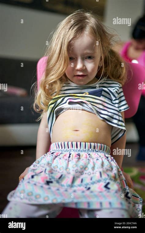 Cute little girl artist sitting on chair showing her pained belly Stock Photo - Alamy