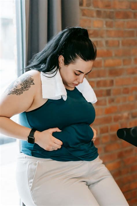 Plus size woman holding fat fold on belly · Free Stock Photo