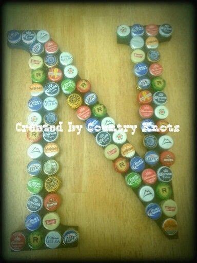 the letter k made out of beer bottle caps is displayed on a wooden table top