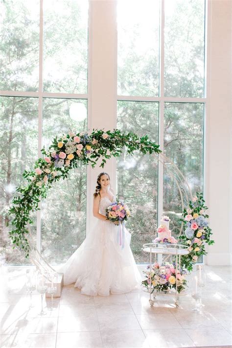 a woman in a wedding dress standing next to a table with flowers and ...