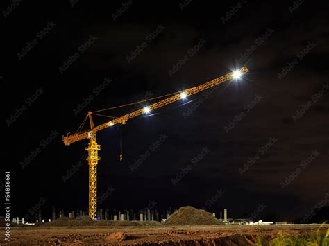 Yellow tower crane at construction site by night time Stock Photo ...