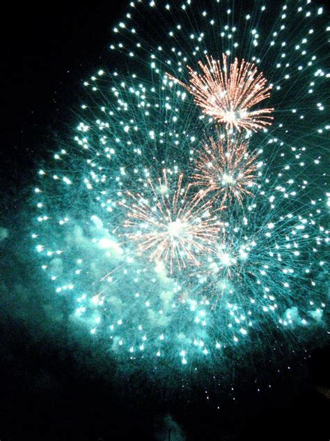 fireworks are lit up in the night sky with green and red lights on it's side