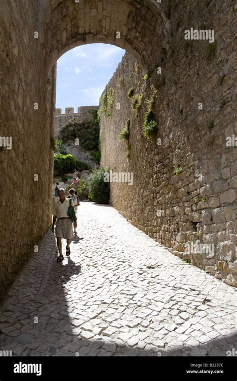 Typical street of Obidos near the castle fortifications. Obidos is a very well preserved ...