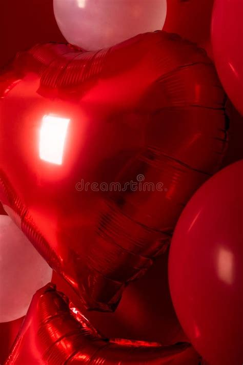 Metallic Balloon in the Shape of a Red Heart with a Red Background ...