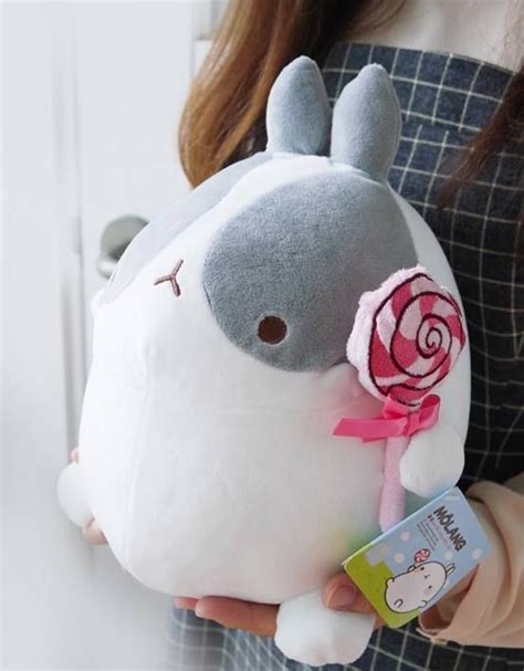 a person holding a stuffed animal with a flower on it