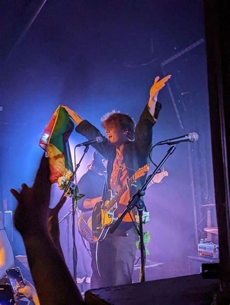 wilbur holding a pride flag on a stage at one of the lovejoy's concerts Hot British Men, British ...