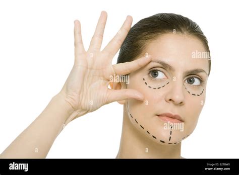 Woman with plastic surgery markings on face, touching face, looking away Stock Photo - Alamy