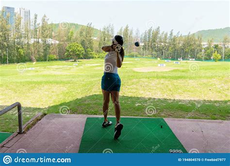 Asian Golfer Woman Swing Golf Ball Practice At Golf Driving Range For ...